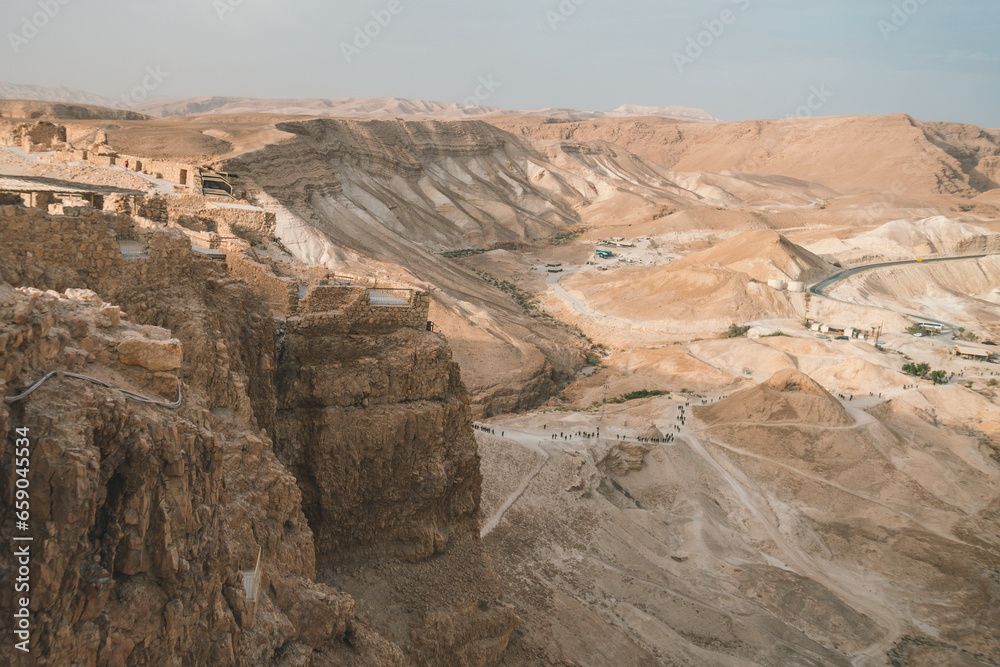 King Herod's northern palace. Masada national park, Israel. Scenic view of Masada fort on the hill and many people at the foothill. Tourism in Israel. The Judean desert's landmarks. Travelling