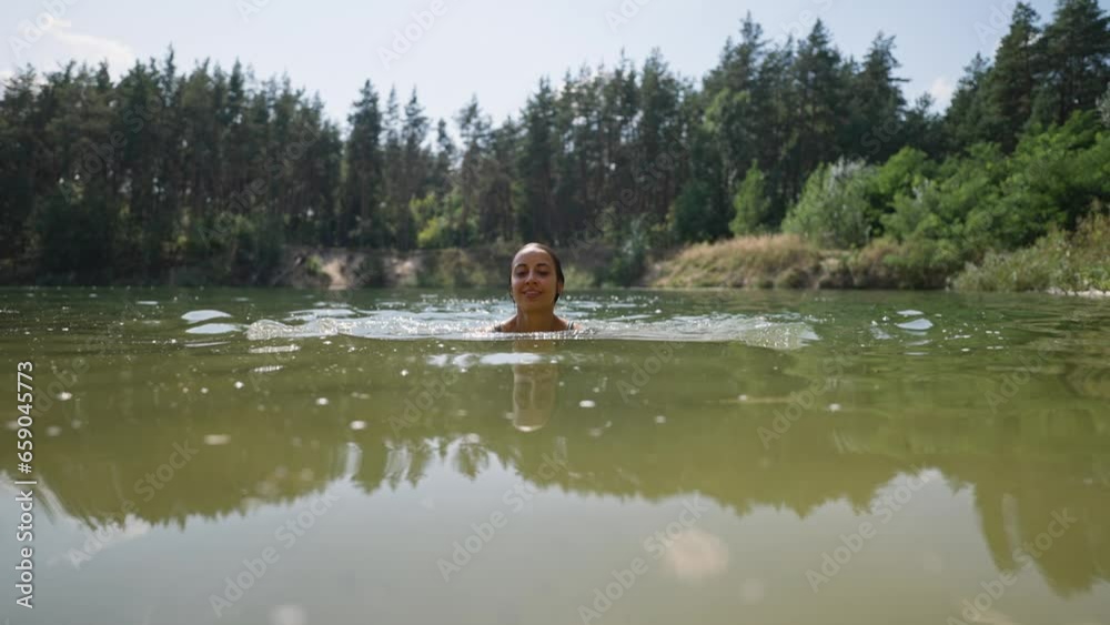 young tanned sexy woman on summer vacation or holiday swimming in alpine mountain lake, standing up from cold fresh clean water to get refreshed in heat, natural outdoor lifestyle young tanned sexy woman on summer vacation or holiday swimming in alpine mountain lake, standing up from cold fresh clean water to get refreshed in heat, natural outdoor lifestyle
