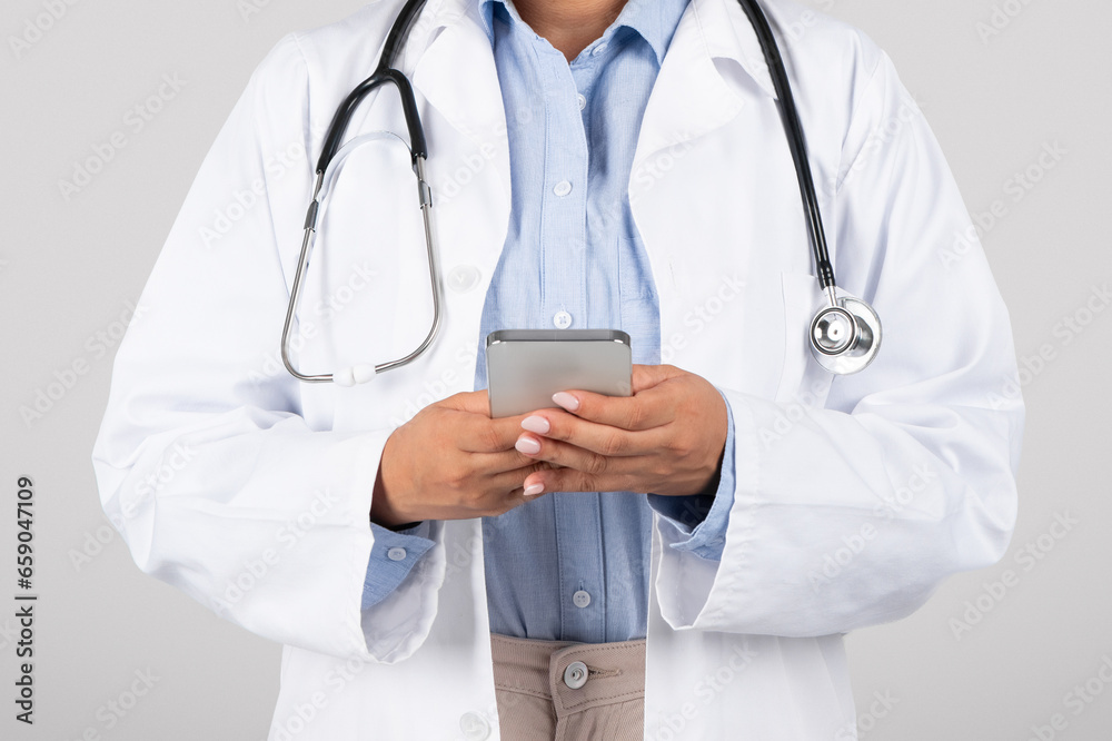 Closeup of woman doctor using cellphone in studio Closeup of woman doctor using cellphone in studio