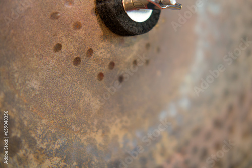 Close-up of a rusting metal cymbal . Selective focus.