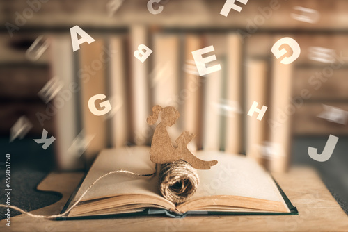 girl with dyslexia holds a book. Flying tangled letters in the air. The child learns to speak and read correctly