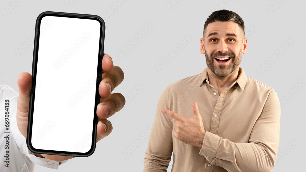 Cheerful mature european man point finger at smartphone with empty screen, enjoy gadget