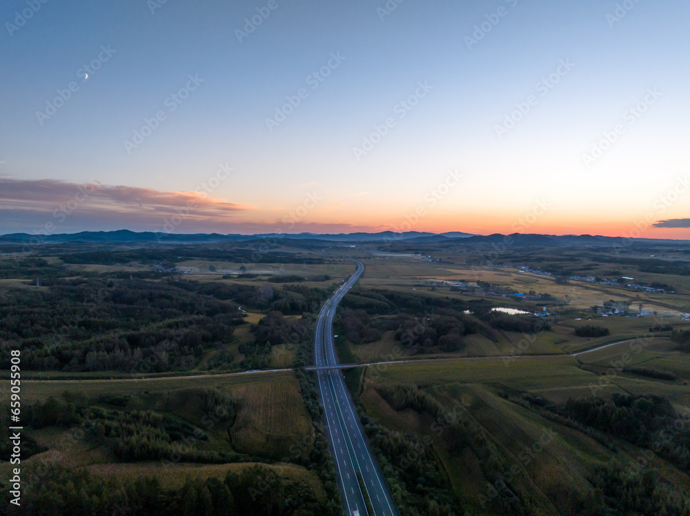 aerial view of highway in countryside at sunset