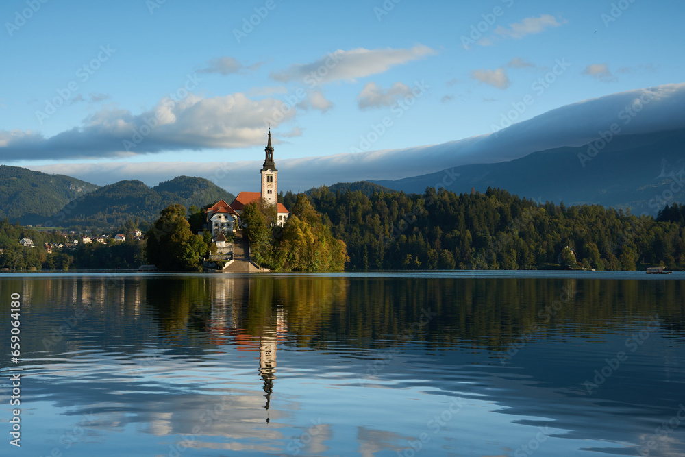 Panoramic view of Lake Bled with the church on the island and mountains in the background in the morning.