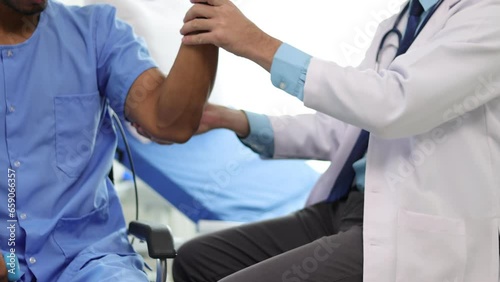 Wallpaper Mural Doctor in hospital is practicing physical therapy on the arm of a male patient who is lifting a dumbbell. Torontodigital.ca