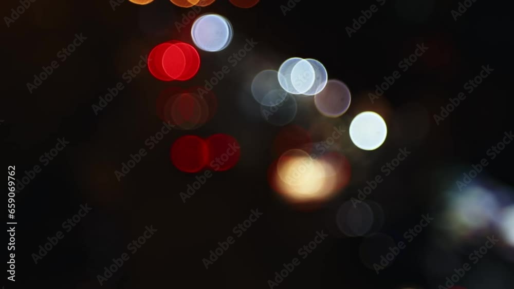 Blurred car lights bokeh in traffic on the road at night. Beautiful glittering bokeh in dark blurry background at night. Blurred car lights bokeh in traffic on the road at night. Beautiful glittering bokeh in dark blurry background at night.