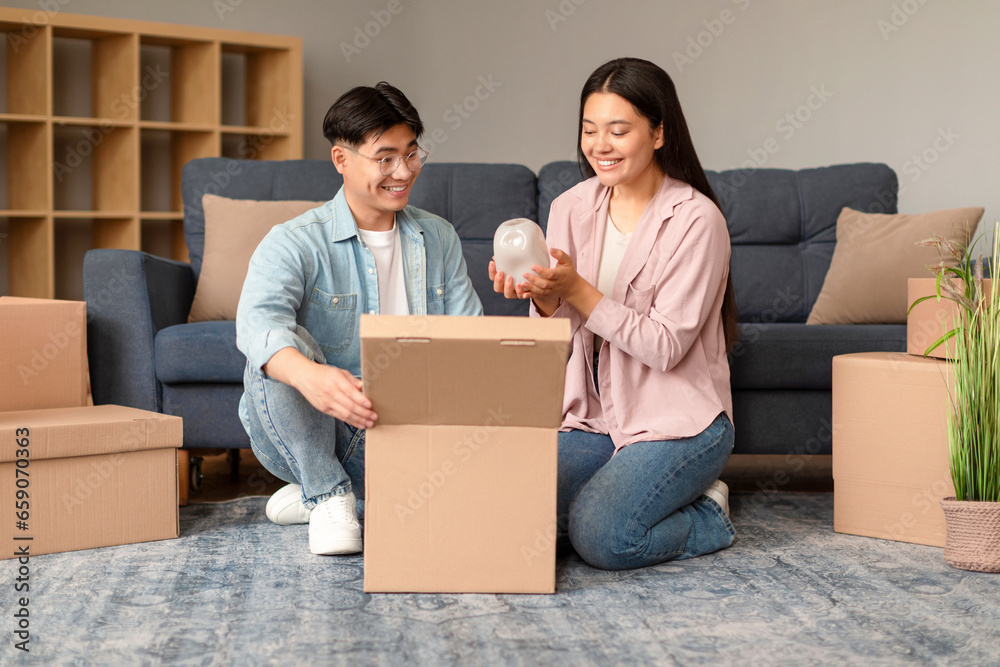 Japanese couple packs belongings in boxes preparing moving new home Japanese couple packs belongings in boxes preparing moving new home
