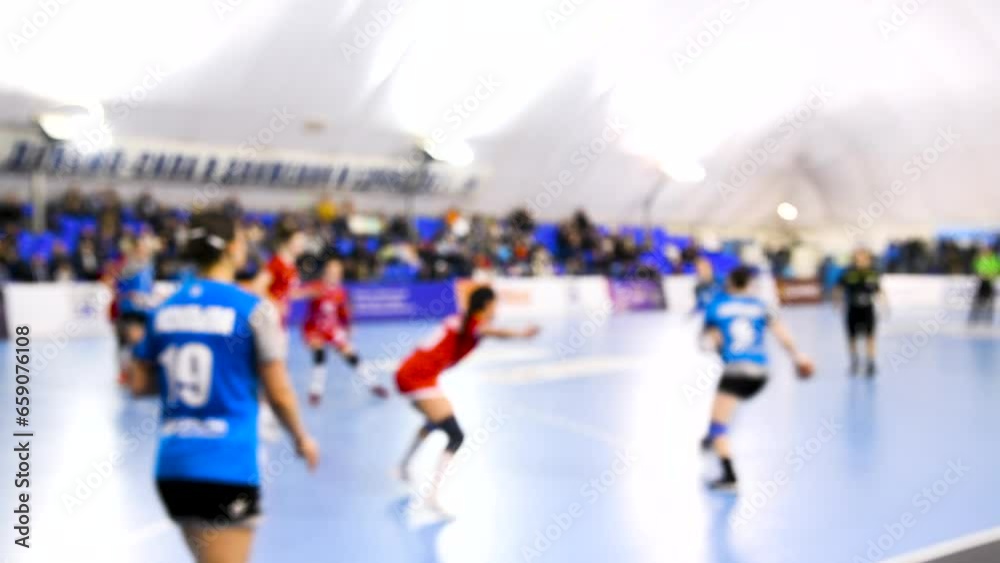 A women's sports team plays indoor handball. Blurry. A women's sports team plays indoor handball. Blurry.