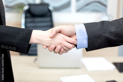Business people shaking hands and finishing up the meeting. Contract and business deal concept.