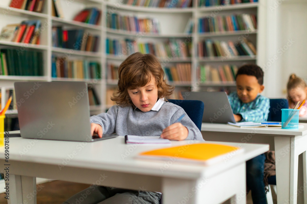 Children in class exploring education via laptops Children in class exploring education via laptops