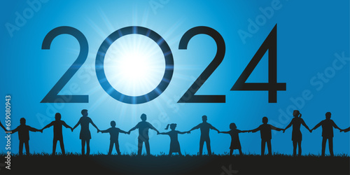 Un groupe d’hommes et de femmes de tous les âges ainsi que des enfants se donnent la main en signe de fraternité pour l’arrivée de l’année 2024.