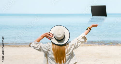 young woman uses laptop computer on the beach. distance work, freelancer and blogger concept. WiFi unlimited