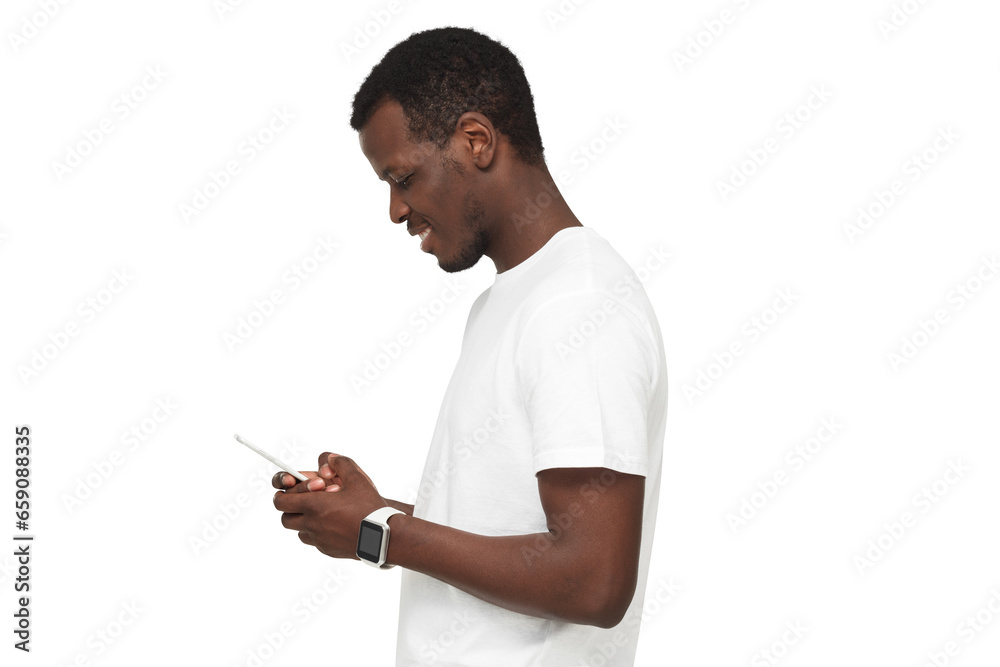 Side view of african american man standing, looking at screen of phone, surfing web and smiling while browsing content Side view of african american man standing, looking at screen of phone, surfing web and smiling while browsing content