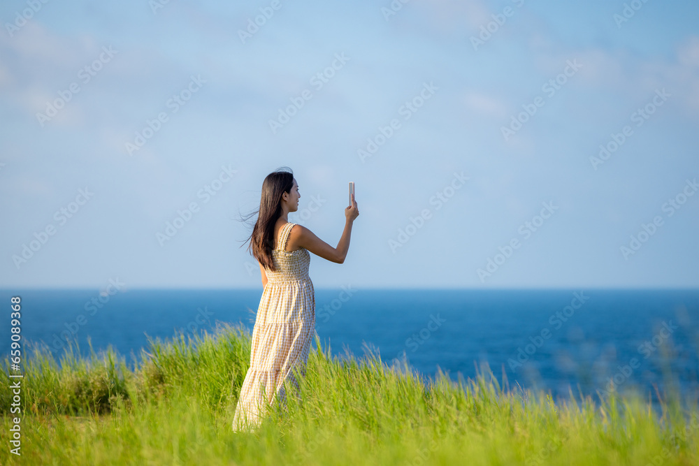 Woman use smart phone to take photo on the sea Woman use smart phone to take photo on the sea