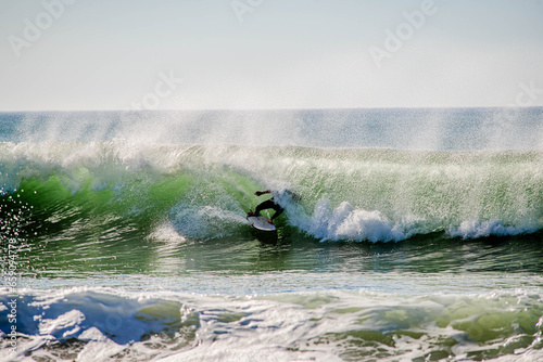 Surfer in a barrel falling under the force of the waves