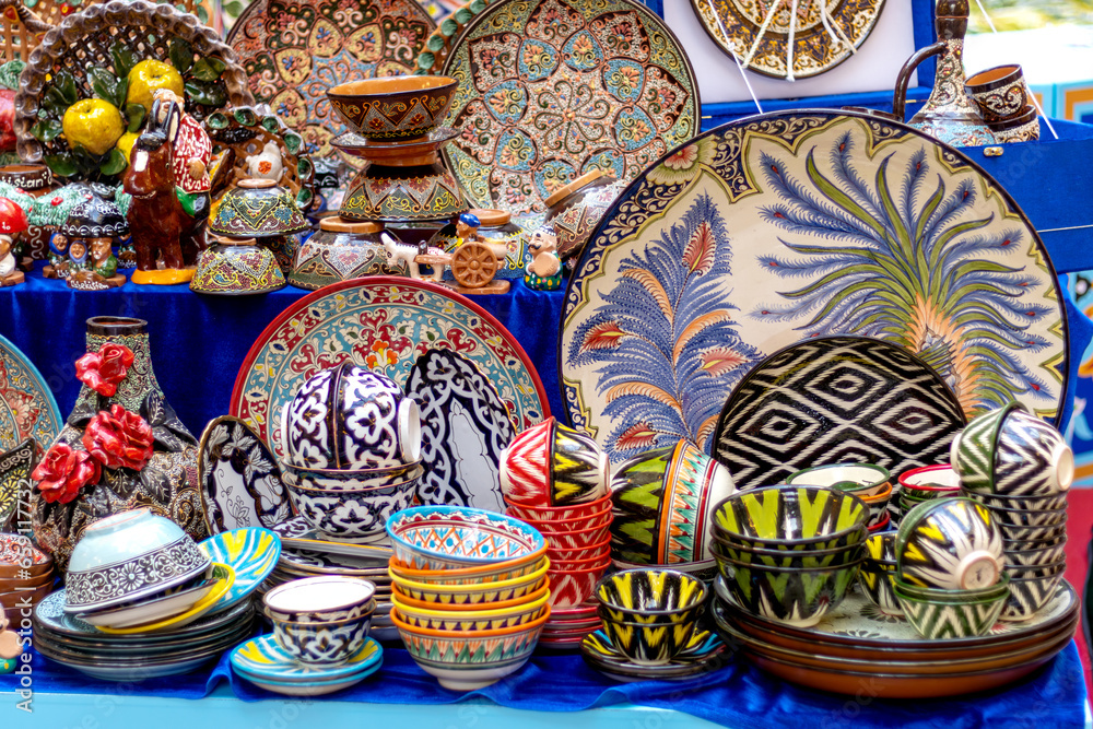 Ornate colorful oriental dishes and ceramics on market window. Silk Road