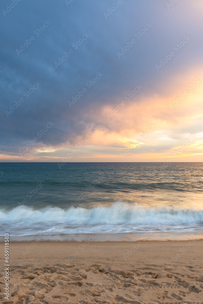 Cloudscape and seascape at ocean sunset with sandy beach in Portugal