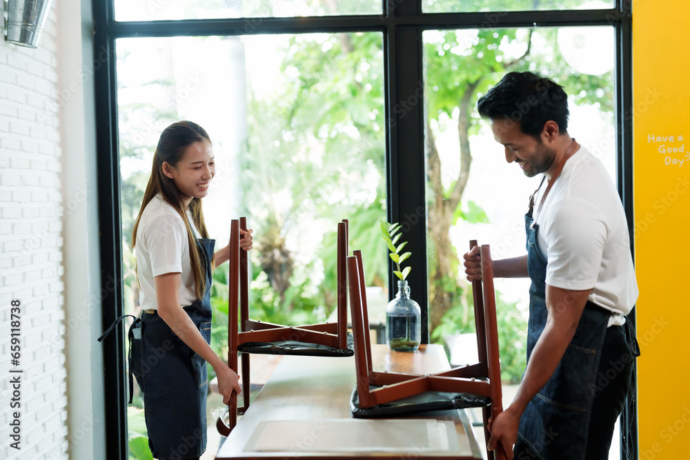 Asian coffee shop owner partner Pair clean and set the table. After the customer returns to prepare to receive the customer A congratulatory applause held in a small family business cafe.