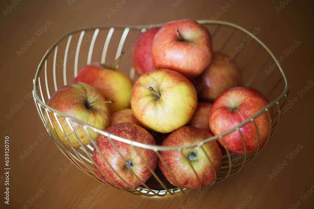 Apples in basket. Decorative metal bowl. Fruits on wooden table. Pile of apples. Apples in basket. Decorative metal bowl. Fruits on wooden table. Pile of apples.