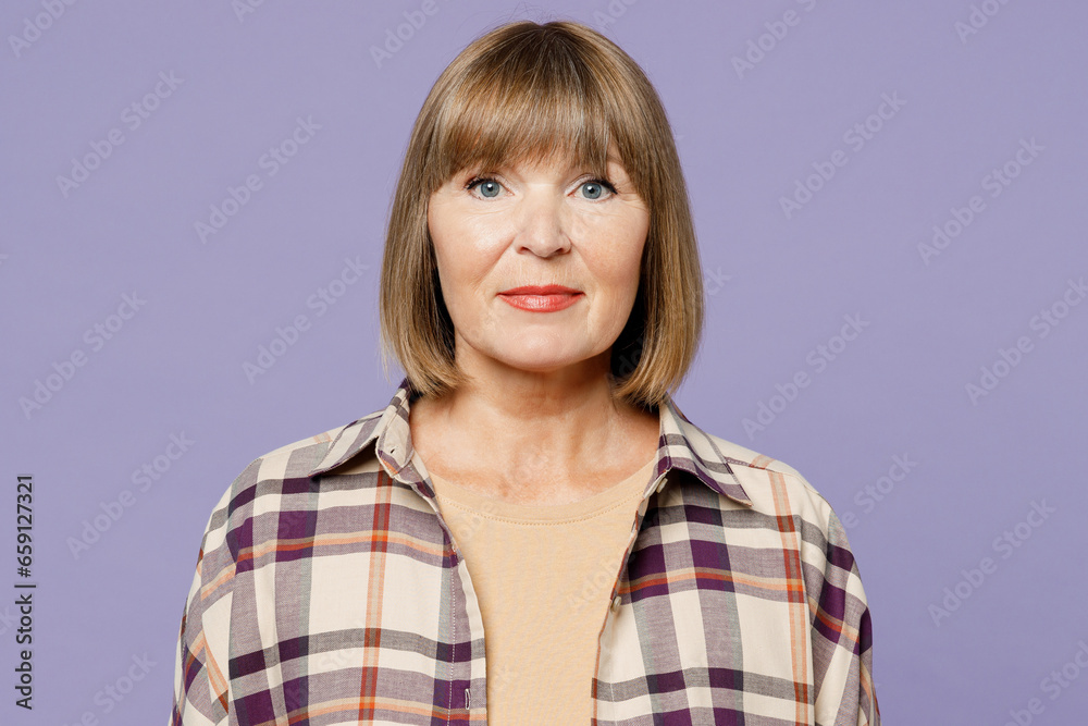 Close up happy smiling cheerful fun elderly gray-haired woman 50s years old wear beige t-shirt shirt casual clothes looking camera isolated on plain pastel light purple background. Lifestyle concept. Close up happy smiling cheerful fun elderly gray-haired woman 50s years old wear beige t-shirt shirt casual clothes looking camera isolated on plain pastel light purple background. Lifestyle concept.