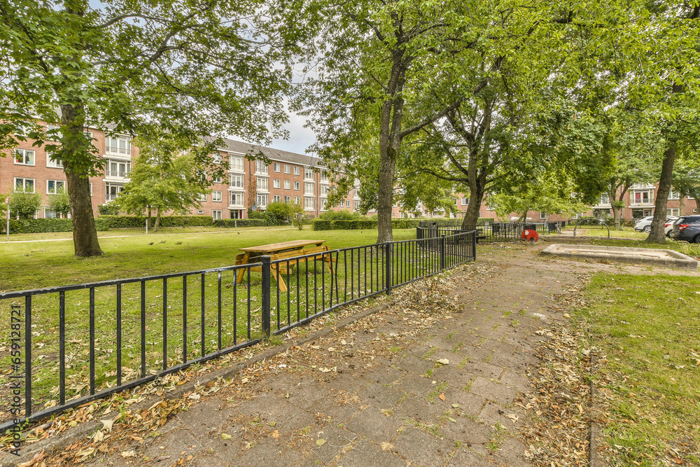an empty park with trees and benches in the fore - image taken from google street view, looking south west