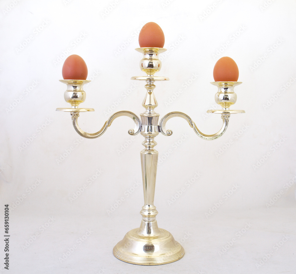 Three eggs on a candelabra isolated against a clear background with copy space Three eggs on a candelabra isolated against a clear background with copy space
