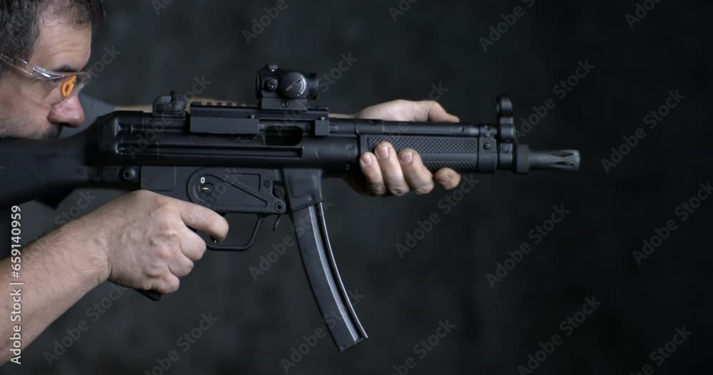 Firing weapon in high-speed, HK SP5K GUN side view. Person aiming and shooting German assault rifle Firing weapon in high-speed, HK SP5K GUN side view. Person aiming and shooting German assault rifle