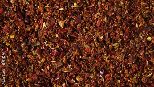 Dried crushed red pepper Gochugaru, close-up. 4K video, counterclockwise rotating. Medium-ground red dry pepper for kimchi, gochujang and other savory dishes. Popular spicy condiments. photo