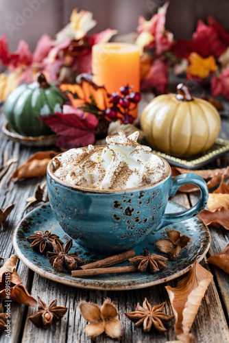 Autumn pumpkin spice latte with milk and cream on wooden table