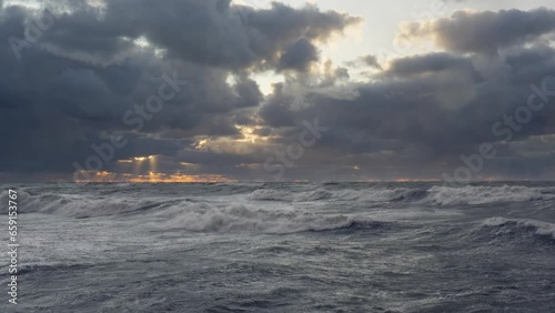 Sunset during a storm, the sun's rays try to break through the rain clouds and the air is full of water droplets covering the camera lens