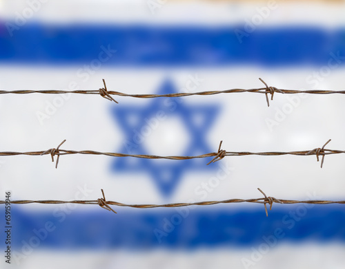 Metal fence with barbed wire on a Israeli flag. Separation concept, borders protectionm.