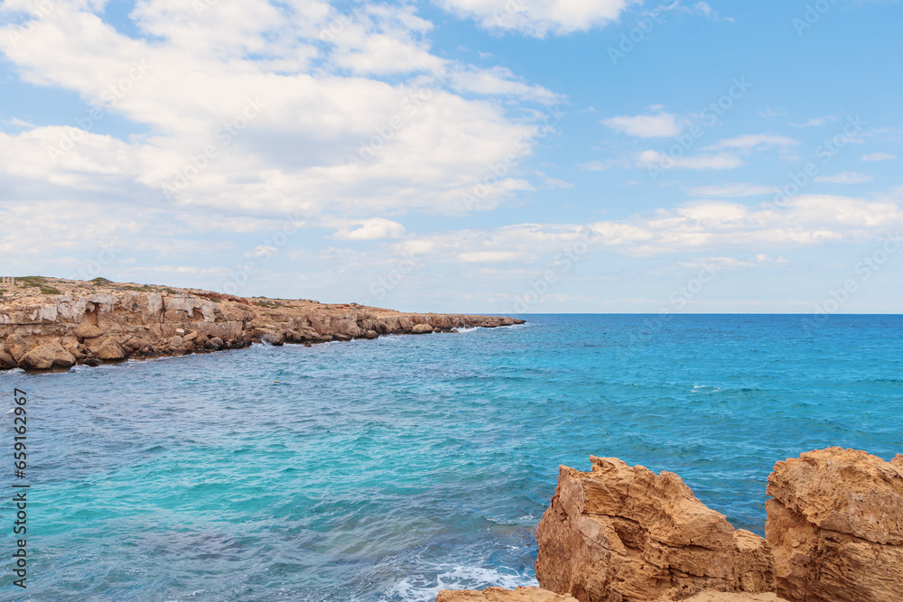 Landscape of the blue lagoon between the rocky bay, blue sky with white clouds in the background