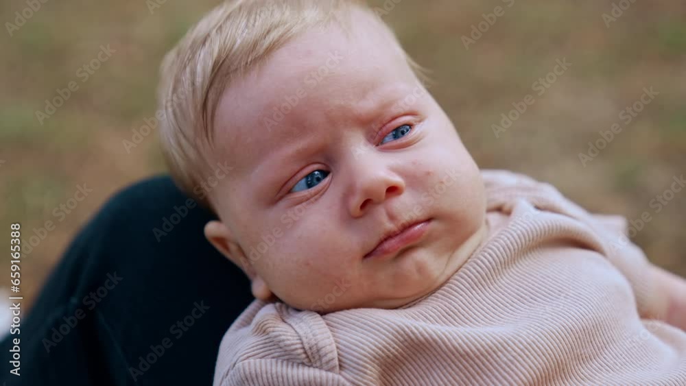 Blue-eyed blond infant boy looking really serious. Little baby just going to cry. Close up. Blue-eyed blond infant boy looking really serious. Little baby just going to cry. Close up.