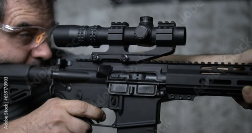 Shooting a single shot with an assault rifle detail close-up of finger pulling trigger in super slow-motion 800 fps