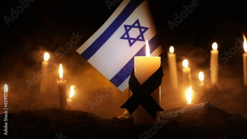 Israel flag on burning dark background with candle. Attack on Israel, mourning for victims concept or Concept of crisis of war and political conflict. Selective focus