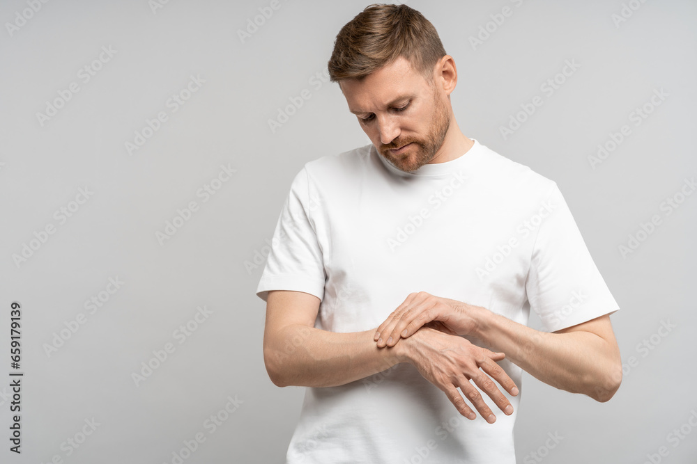 Unwell frowning man suffers from tunnel syndrome due to prolonged use of computer, neuralgia, injuries. Fatigue from long work on laptop. Annoyed unhealthy guy touching place pinched nerve in wrist. Unwell frowning man suffers from tunnel syndrome due to prolonged use of computer, neuralgia, injuries. Fatigue from long work on laptop. Annoyed unhealthy guy touching place pinched nerve in wrist.