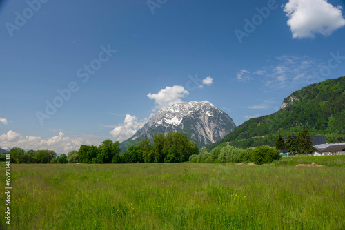 Summer austrian landscape with green meadows and Grimming mountain (2.351 m), an isolated peak in the Dachstein Mountains, in Styria region, Austria