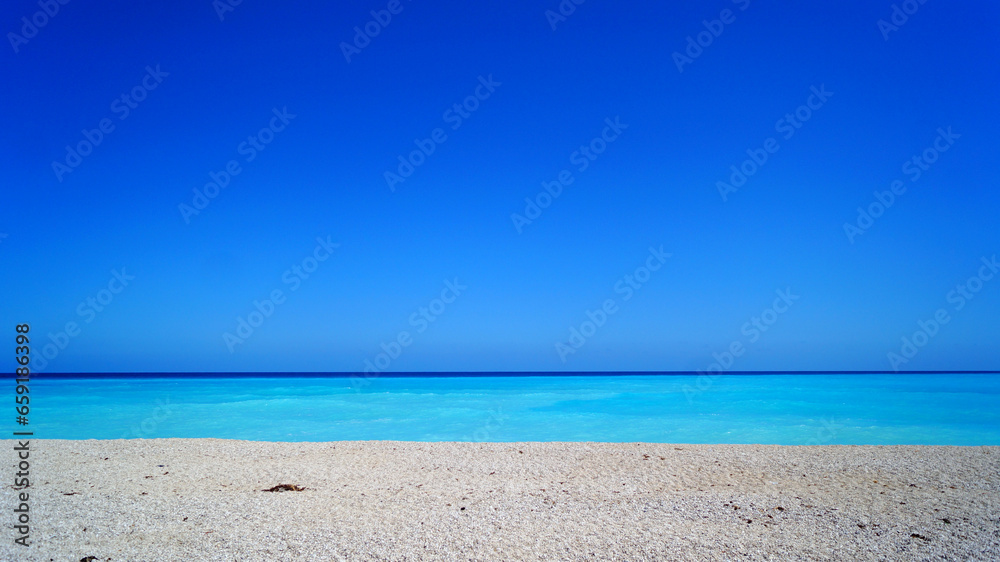 Fototapeta premium Sunny and calm day in Caribbean Sea, Dominican Republic. Close up of white sand, turquoise gradient colors and sea without waves.
