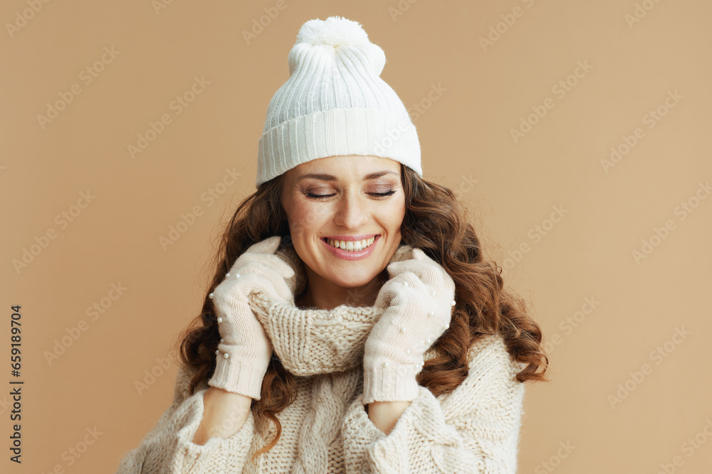 smiling modern woman in beige sweater, mittens and hat smiling modern woman in beige sweater, mittens and hat