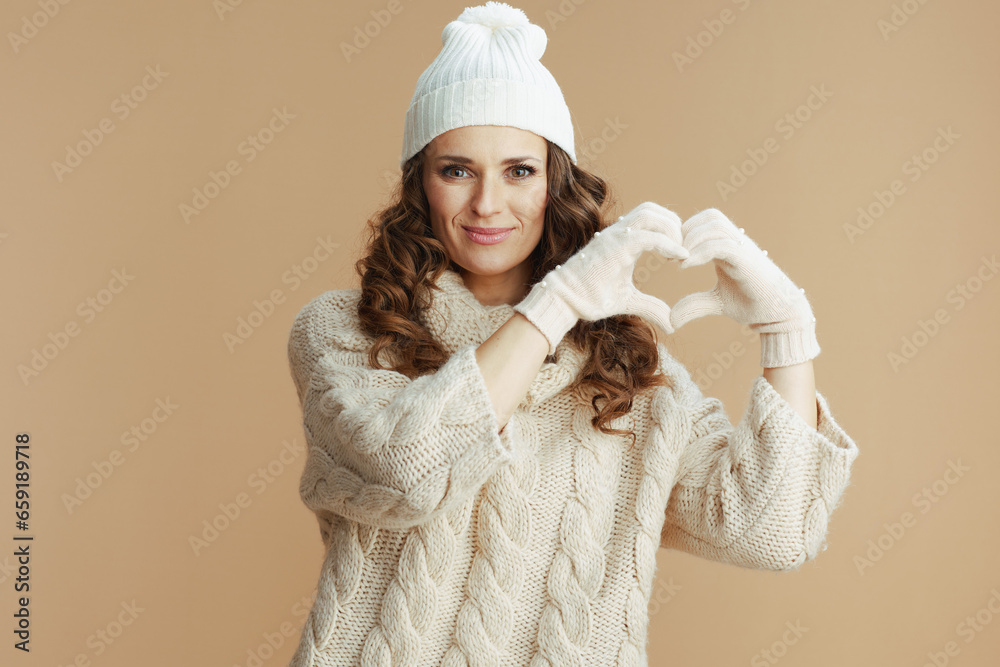 happy trendy woman showing heart hands isolated on beige happy trendy woman showing heart hands isolated on beige