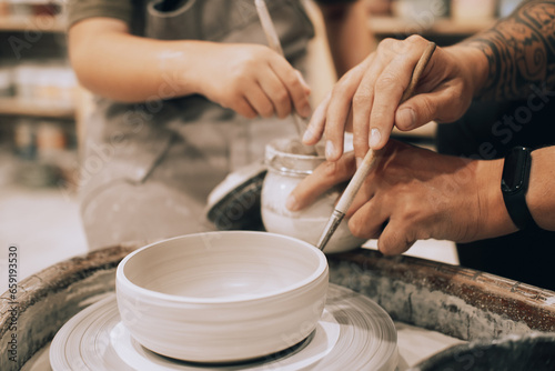 Confident young man and little boy making ceramic pot on the pottery class © Raisa Kanareva