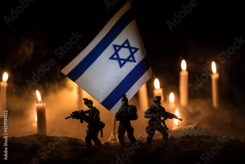 Israel flag on burning dark background with candle. Attack on Israel, mourning for victims concept or Concept of crisis of war and political conflict. photo