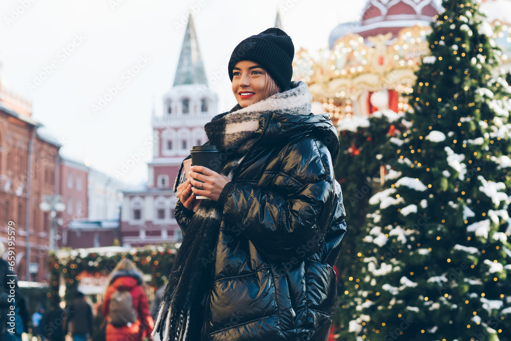 Beautiful woman standing on Red Square decorated with Christmas trees