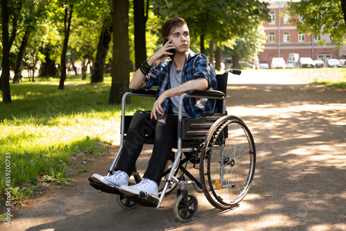 A young man in a wheelchair talks on the phone. © Raisa Kanareva