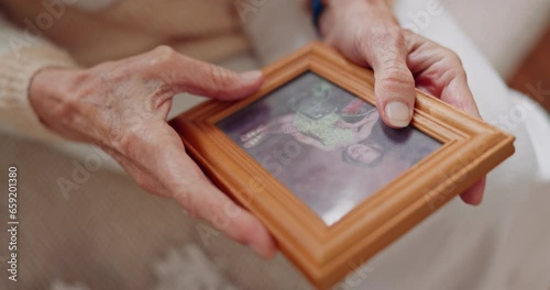 Frame, picture and hands of senior person for nostalgia, memories and thinking of past in home. Retirement home, elderly and closeup of photo to remember, mourning and depression with Alzheimers photo