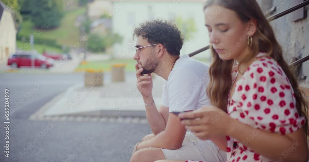 Woman using smart phone while sitting by boyfriend Woman using smart phone while sitting by boyfriend