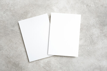Two paper invitation cards on trendy grey background with copy space for card design presentation