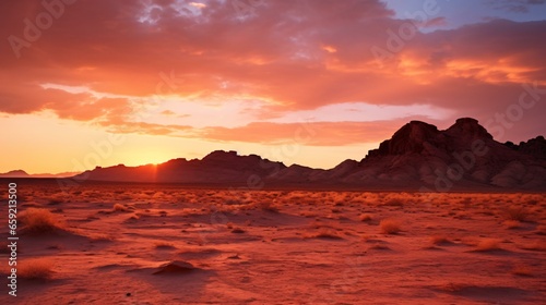 A stunning sunset over a desert landscape with majestic mountains in the distance