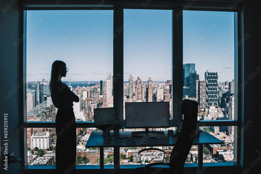 Businesswoman looking at cityscape in modern office