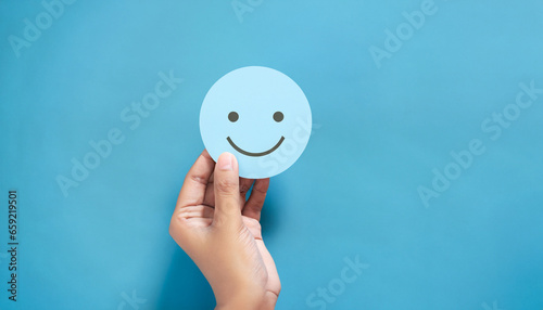 Hand holding blue paper cut happy smile face, Positive thinking, Mental health assessment , World mental health day concept